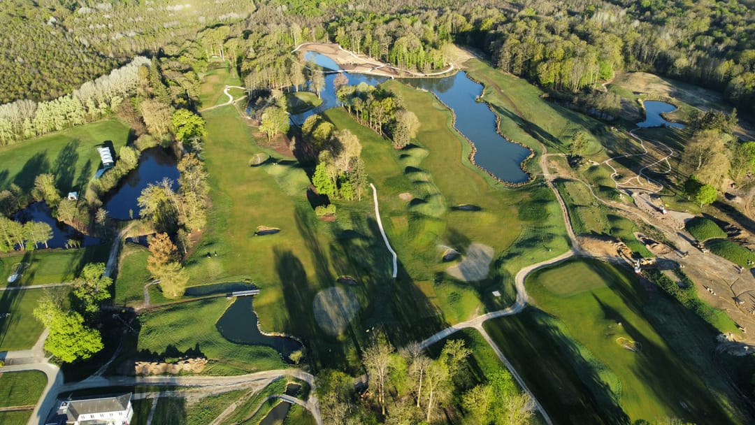 Vue aérienne du golf, greens en île et plan d’eau